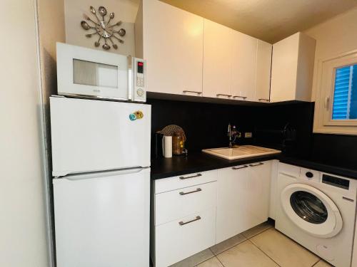 La cuisine est équipée d'un réfrigérateur blanc et d'un four micro-ondes. dans l'établissement Appartement T2 Cabine - Balcon - Près de la plage - FR-1-309-513, à Argelès-sur-Mer