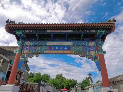 a large arch in a city with a sky at Beijing Tangfu Nanluoguxiang Tian an Men Lama Temple San Li Tun Snack Street Hotel,Free Laundry Dry Service and Free Afternoon Tea &professional Free Tour Ticket Service with English Speaking Staff in Beijing