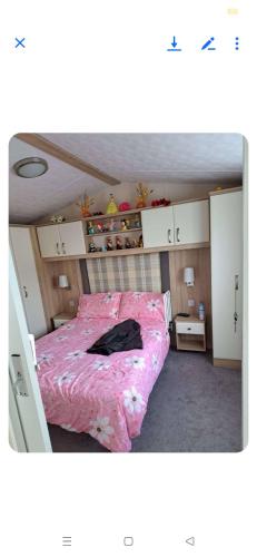 a bedroom with a bed with a pink blanket at Home from home on The Grange in Ingoldmells