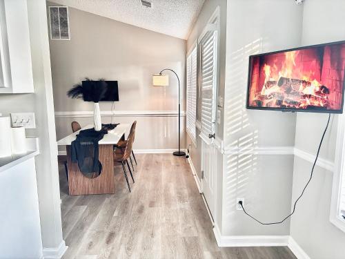 a living room with a desk and a tv on a wall at King Suite - Private Bath - Gym - Hot Tub - Game Room in Ellenwood