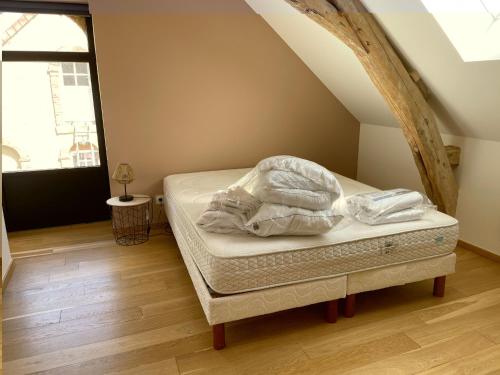 un letto in una camera con mansarda di Gîte de charme près du Mans pour 4 avec piscine naturelle - FR-1-410-473 a Teloché