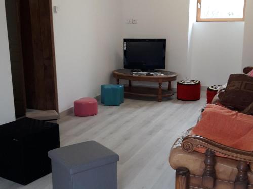 a living room with a couch and a tv and a table at Nermond - FR-1-591-751 in Crozon-sur-Vauvre