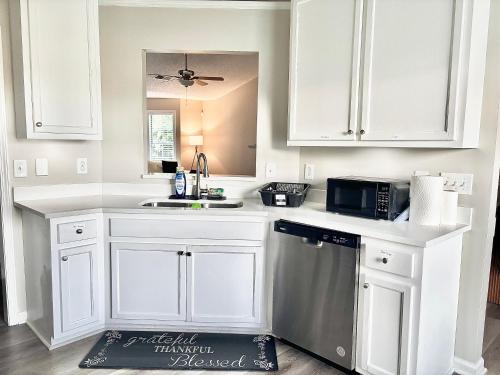 a kitchen with white cabinets and a sink and a microwave at King Suite - Half Bath - Gym - Game Room - Hot Tub in Ellenwood