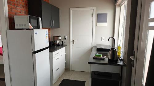 a small kitchen with a refrigerator and a table at Casa Shalom 2 Room App! Internet! Parking! Sauna! Quiet! Central! Esperanza village! in Hohenau