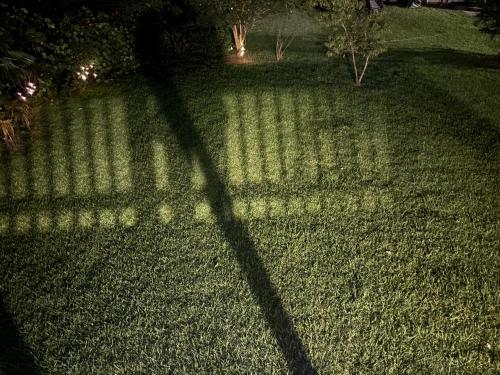a shadow of a fence on a lawn at night at King Suite - Half Bath - Gym - Game Room - Hot Tub in Ellenwood