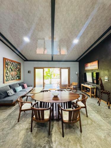 a living room with a table and chairs and a couch at Casa Carambola Bioluminicencia, Tortuga y Quesera in Paquera
