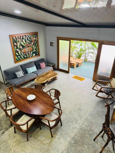 a living room with a couch and a table and chairs at Casa Carambola Bioluminicencia, Tortuga y Quesera in Paquera