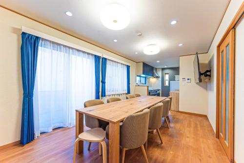 a dining room with a wooden table and chairs at Third Place Tokyo - Aoto - in Tokyo