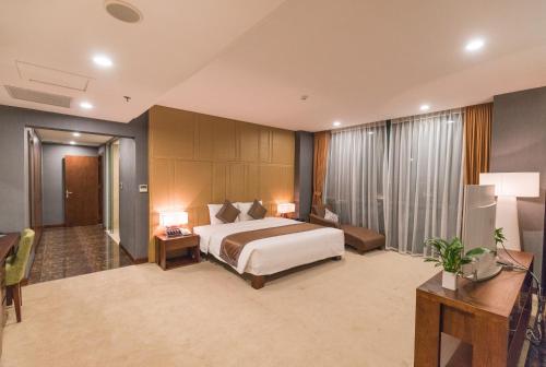 a hotel room with a large bed and a desk at Bien Bac Hotel in Móng Cái