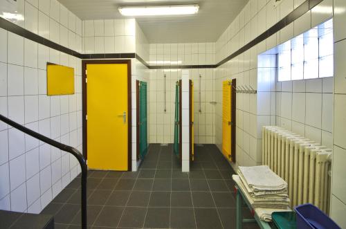 a bathroom with yellow doors and a bench in it at Eastfield in Oostduinkerke