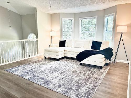 a living room with two white couches and a rug at Queen Suite - Gym - Game Room - Hot Tub in Ellenwood