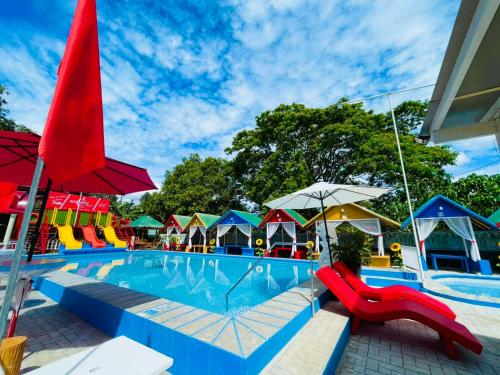 a swimming pool with colorful slides and umbrellas at Red Apple Hotel and Resort San Juan Batangas in San Juan