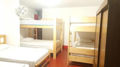 a room with three bunk beds in a room at Hospedaje con vista ala laguna de huacachina refugio en el oasis in Ica