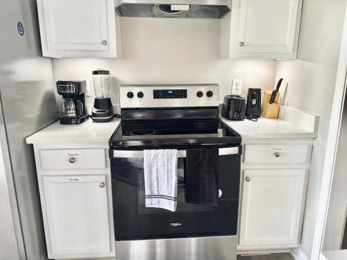 a kitchen with a black stove and white cabinets at Queen Suite - Gym - Game Room - Hot Tub in Ellenwood