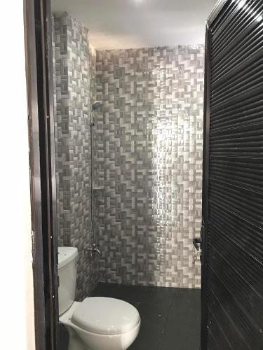 a bathroom with a toilet and a shower at 3Vhin Transient House in Sampong