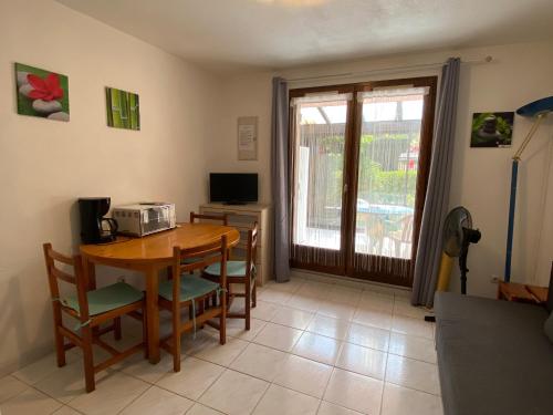 une salle à manger avec une table et un four micro-ondes dans l'établissement Appartement Rez-de-Jardin : Piscine Proche Plage - FR-1-732-8, à Argelès-sur-Mer