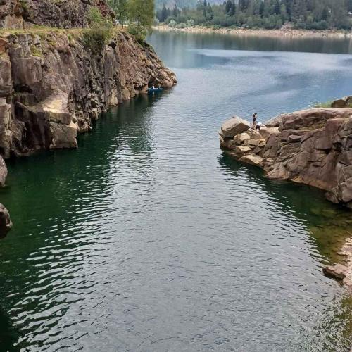 a person standing on the edge of a body of water at Holiday home in Ceppo Morelli - Piemont 52109 in Ceppo Morelli