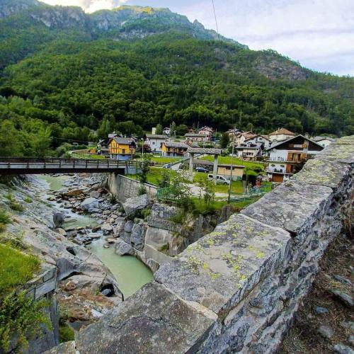 a bridge over a river next to a mountain at Holiday home in Ceppo Morelli - Piemont 52109 in Ceppo Morelli