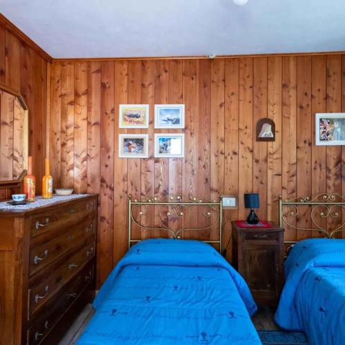 a bedroom with two beds and wooden walls at Holiday home in Ceppo Morelli - Piemont 52109 in Ceppo Morelli