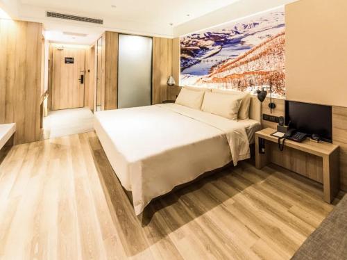 a bedroom with a large bed and a television at Atour Hotel Harbin Nangang District Government in Harbin