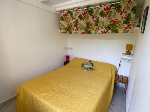 une chambre avec un lit avec un couvre-lit jaune dans l'établissement Pavillon lumineux avec terrasse à 500m de la plage, parking sécurisé, 6 couchages - FR-1-732-52, à Argelès-sur-Mer