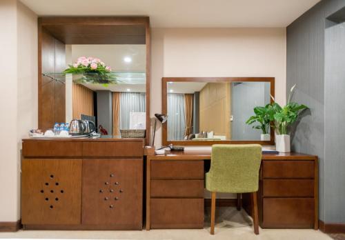 a vanity with a mirror and a desk with a chair at Bien Bac Hotel in Móng Cái
