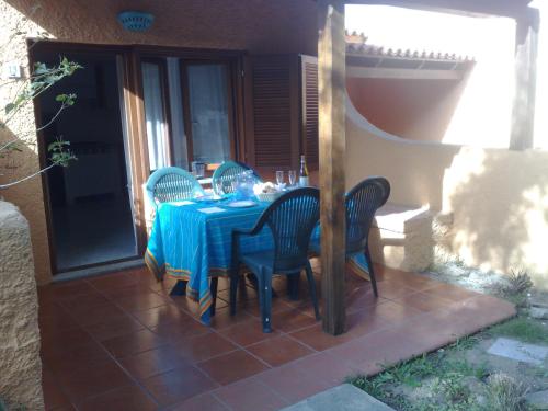 a table with chairs and a blue table cloth on a patio at Residence La Pineta in Budoni