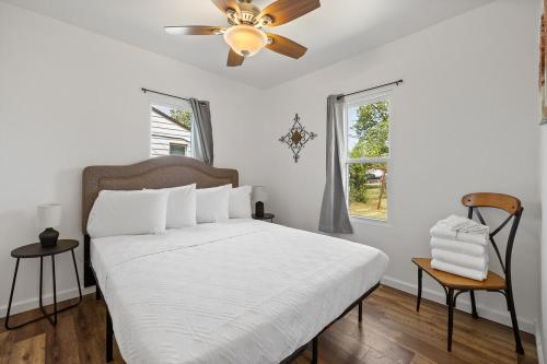 Un dormitorio blanco con una cama y un ventilador de techo. en The Holcomb House, en Rapid City