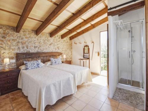 ein Schlafzimmer mit einem Bett und einer ebenerdigen Dusche in der Unterkunft Nice holiday home with private pool in Manacor