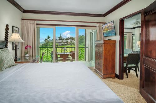 a bedroom with a large bed and a balcony at Waipouli Beach Resort and Spa Kauai by OUTRIGGER in Kapaa