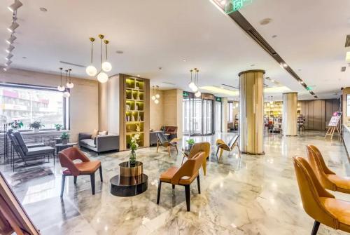 a lobby with chairs and tables in a building at Atour Hotel Harbin Nangang District Government in Harbin