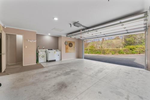 an empty room with a large window and a garage at Soak & Stay Acacia Bay - spa, pet, family friendly in Taupo