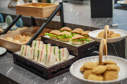 a buffet line with sandwiches and pastries and rolls at SSAW Boutique Hotel Hefei Intime Centre in Hefei