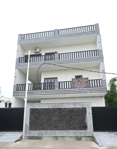 a tall white building with a sign on it at The Villas Homestay in Jammu