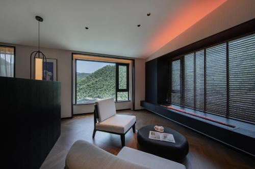a living room with a couch and a chair and windows at Non Hills in Anji