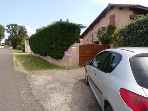 a white car parked on the side of a road at Chambres Du Petit Bonheur in Biscarrosse