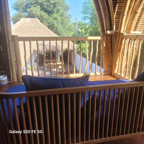 a balcony with a view of a patio at Tricky Trees Lodges in Gili Air