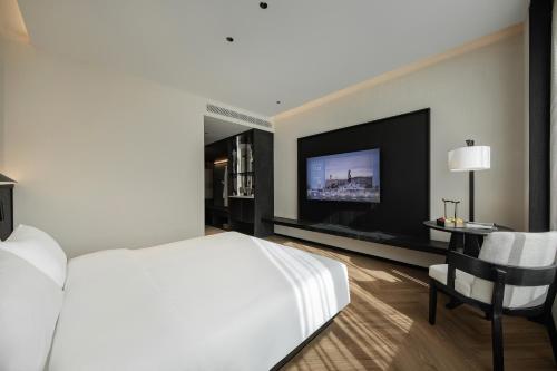 a bedroom with a bed and a tv and a chair at Non Hills in Anji