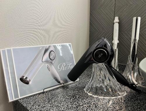 a bathroom counter with a dispenser and a pair of scissors at GRIDS PREMIUM HOTEL OSAKA NAMBA in Osaka