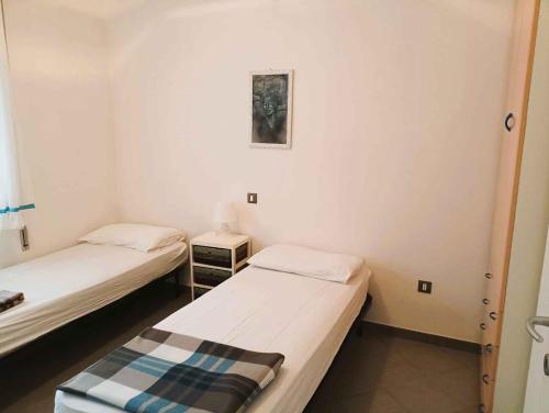 a room with two beds and a picture on the wall at Holiday Homes in Rosolina Mare 48310 in Rosolina Mare
