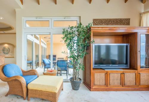 a living room with a tv and a couch at Belizean Cove Estates Beachfront Villas in San Pedro