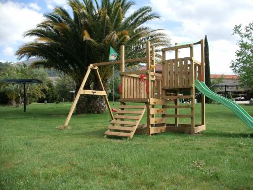 a wooden playground with a slide and a swing at Posada Tresmentiras in Aldeanueva del Camino