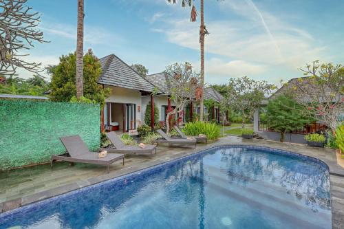 a villa with a swimming pool and palm trees at WK Penida Cottage in Nusa Penida
