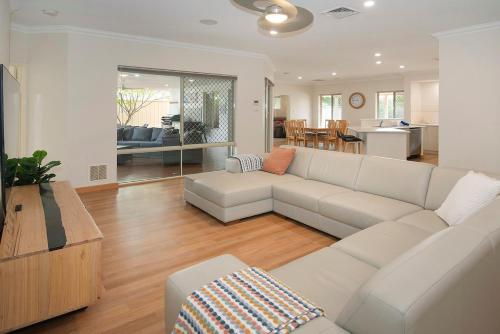 a living room with a white couch and a kitchen at Town Central Entertainers Delight in Busselton