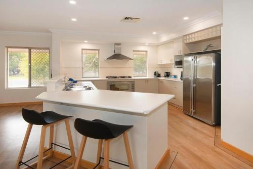 a kitchen with a white counter and a refrigerator at Town Central Entertainers Delight in Busselton