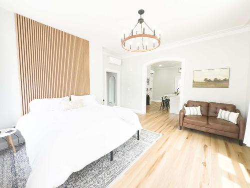a white bedroom with a bed and a couch at Jennifer's Spa-Like Apt King Bed Historic Broadway in Providence