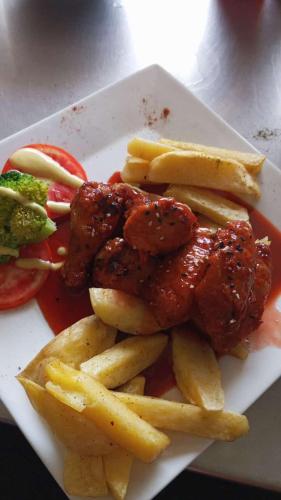 a plate of food with french fries and meat at Hospedaje con vista ala laguna de huacachina refugio en el oasis in Ica