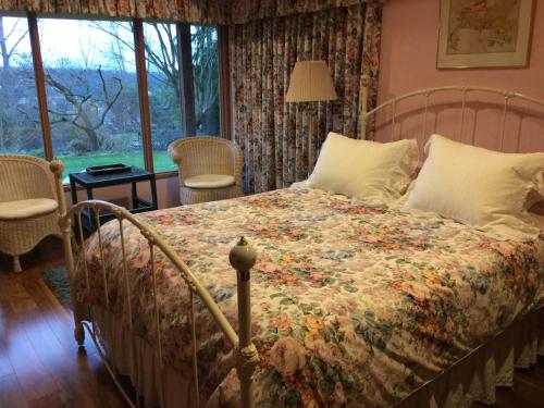 1 Schlafzimmer mit einem Bett mit Blumenbettdecke in der Unterkunft A Cascade View Bed And Breakfast in Bellevue