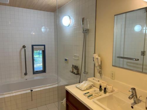 a bathroom with a tub and a sink and a shower at HOTEL HOLIDAY HOME in Kyotango
