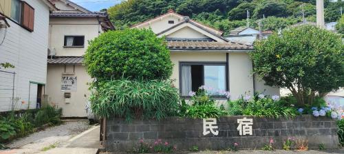 a house with writing on the side of it at Izu Hokkawa Seaside Guesthouse 伊豆北川の家 in Higashiizu